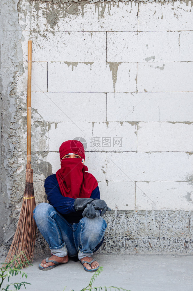 201年5月8日BangkoThailndThilnd当地有扫帚的亚洲人建筑工坐在地的水泥墙旁边图片