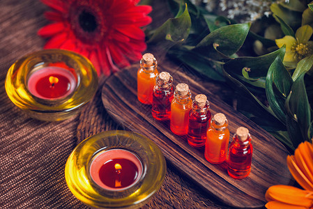 以透明的瓶子装满木板红花和蜡烛上含橙色基本油生活方式高清图片素材