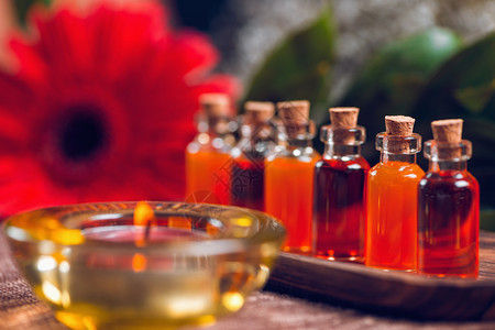 用透明瓶子装满木板和红蜡烛的橙油和花装饰自然的高清图片素材