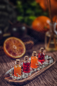 木板上装满红和橙色基本油的瓶子新鲜柑橘水果切成两半健康高清图片素材