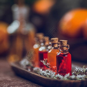 木板上装满红和橙色基本油的瓶子玻璃高清图片素材