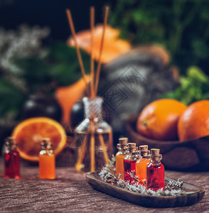 装满红色和橙基本油芳香药瓶的子里面有木棍新鲜柑橘水果被切成两半棍枝高清图片素材