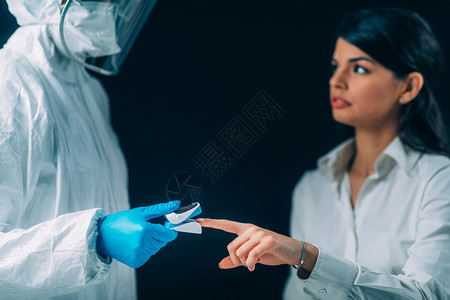 检查血氧水平和的医务人员身戴保护外科手术面罩的病人高清图片