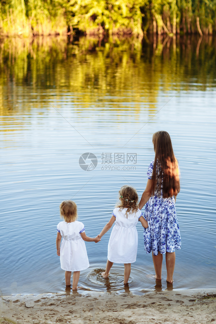 母亲和两个女儿在湖边散步家庭在湖边玩乐图片