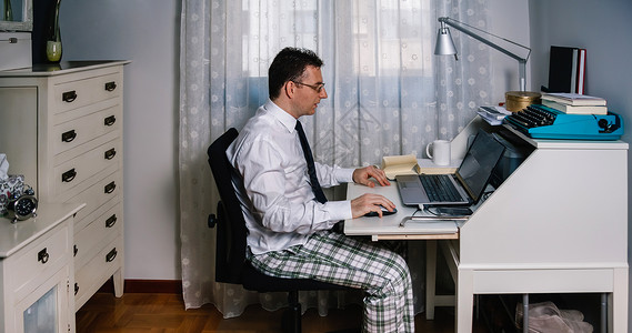 睡衣办公在家工作的人穿着衬衫领带和睡裤的笔记本电脑穿着衬衫领带和睡裤背景