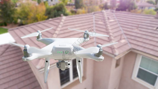 无人驾驶飞机在屋顶上空飞行图片