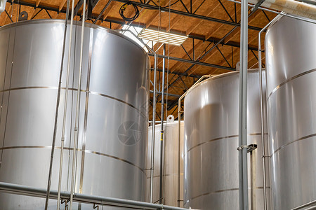 仓库中的大型啤酒酿发酵罐背景图片