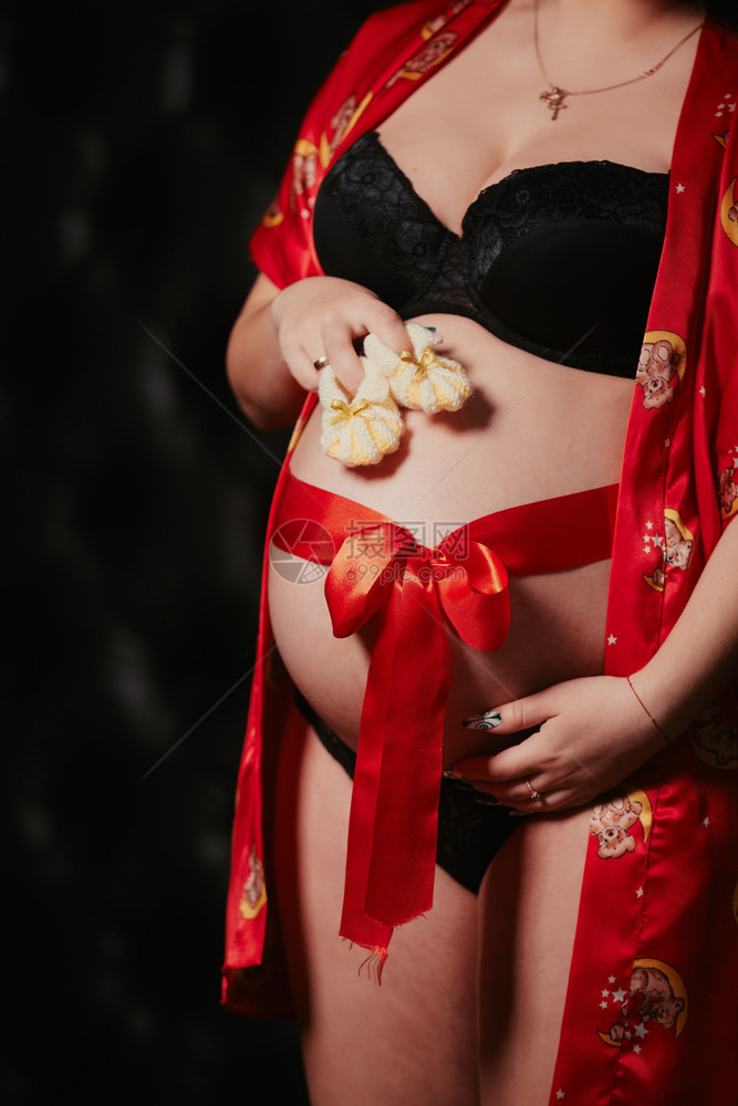 孕妇手握着婴儿鞋图片
