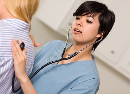 年轻女医生使用听诊器倾患者和生命迹象图片