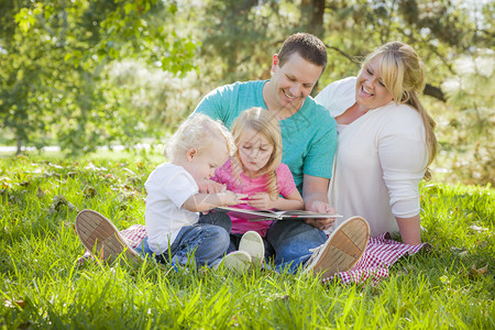 年轻家庭喜欢在公园一起读本书图片
