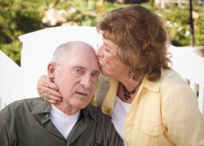 快乐的老年夫妇在公园接吻图片