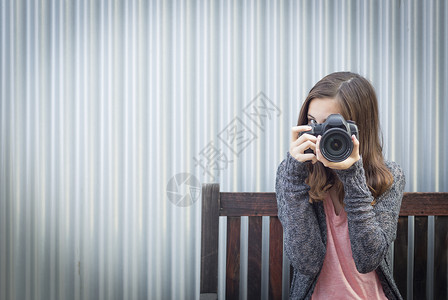 女孩摄影师坐在椅子上对着镜头学习高清图片素材