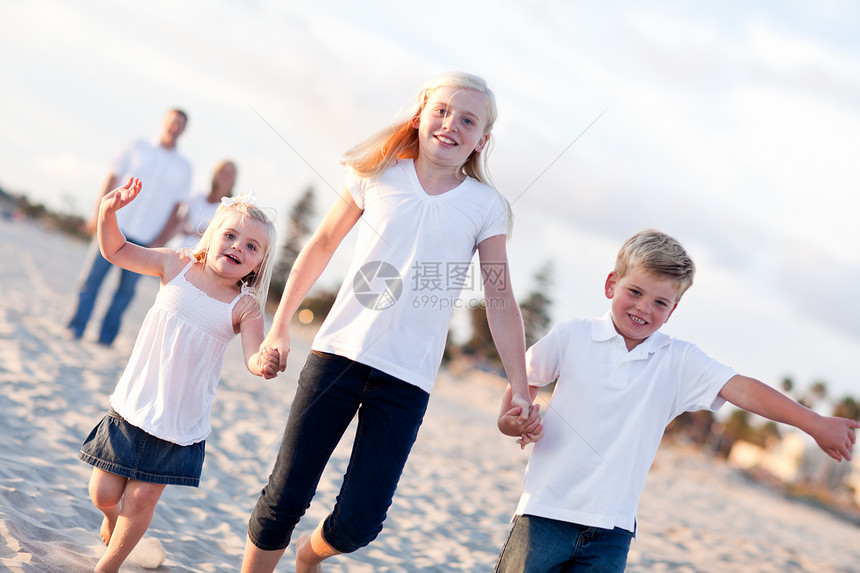 可爱的causin家庭在海滩散步图片