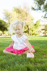 可爱的小女孩在草地上和她的小猪库玩得开心图片