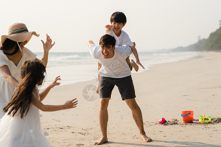 父母和孩子一起在海边玩耍图片