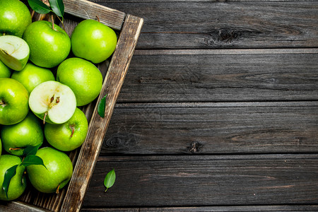 木箱里有多汁的绿苹果和切片黑木箱里有多汁的绿苹果和切片图片