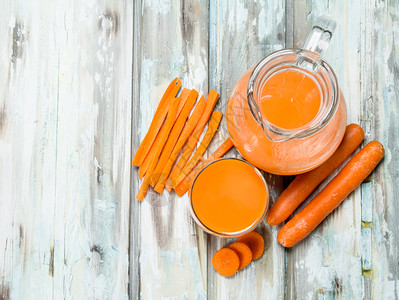 罐子里的胡萝卜汁木制背景的胡萝卜汁图片