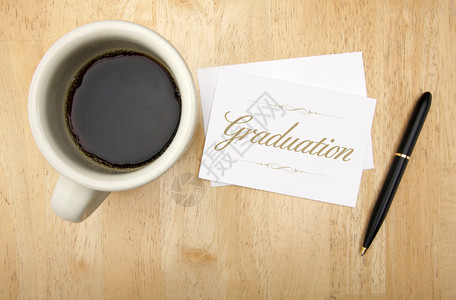 毕业笔记卡和咖啡杯放在木本上图片