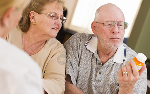 医生或护士向关注的老年夫妇解释处方药图片