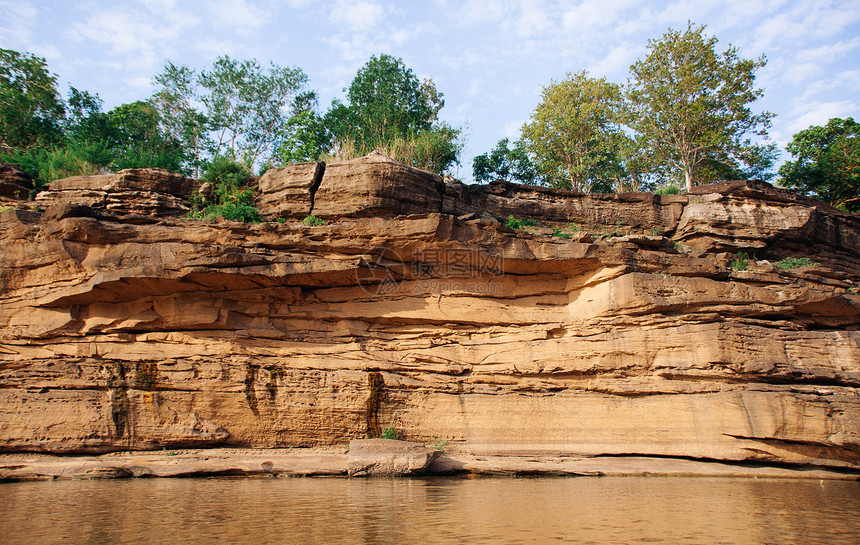 黄沙岩峡谷悬崖海岸线有清晰的Mekong河土壤层和悬崖顶端的绿林禁止使用chanuboratchniTlnd图片