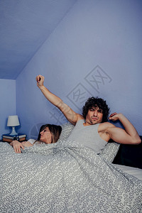 年轻男子在妻睡觉时床上醒来男子在妻睡觉时醒来图片