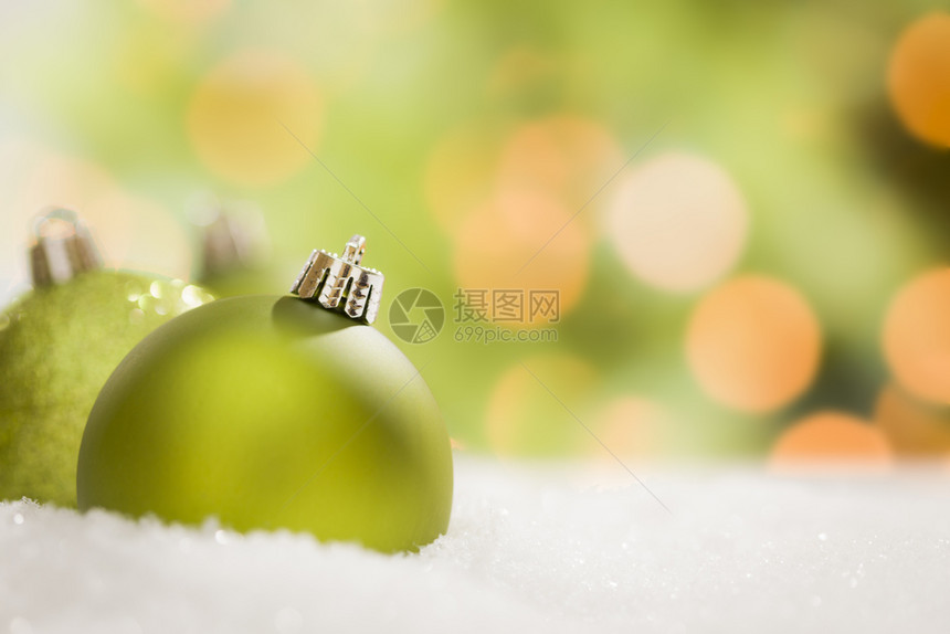 美丽的毛特绿色圣诞装饰品在雪片上抽象的背景上图片