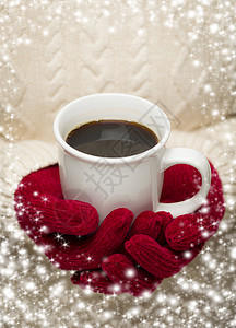 穿着季节红手套的毛衣拿着一杯咖啡和雪花边界图片
