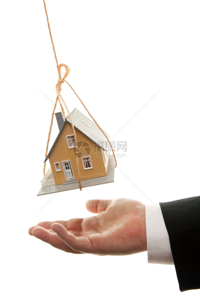 商人将手放在转动房屋下孤立在白色背景上图片