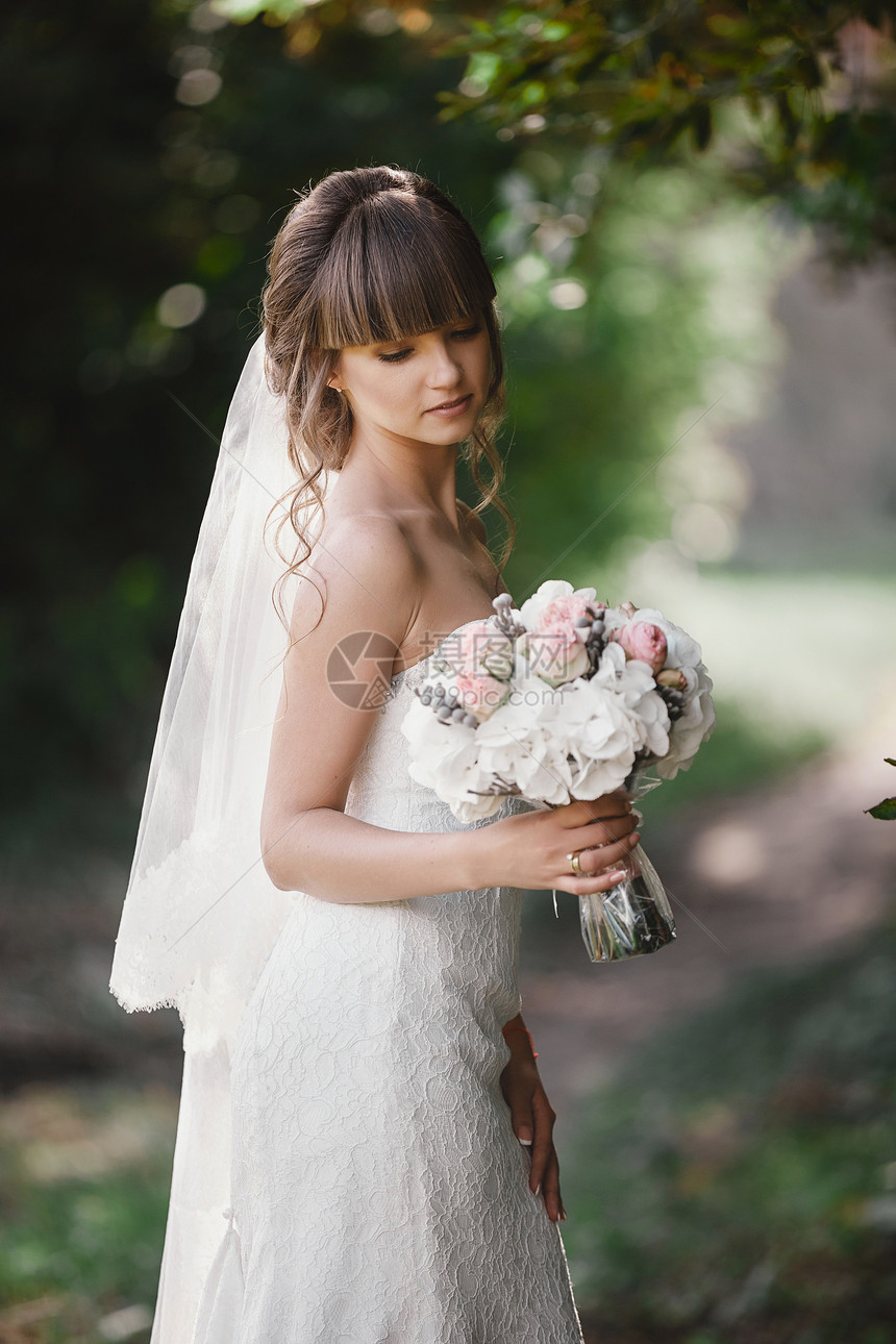 美丽的年轻微笑新娘拿着盛大婚礼花束和粉红色的玫瑰婚礼在和绿色的调子上举行婚礼日图片