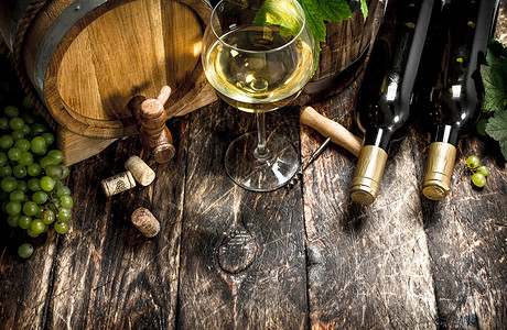 白葡萄酒背景一桶白葡萄酒配有绿枝子木制背景红酒配有绿葡萄枝子背景图片