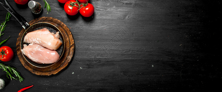 黑纸板上的西红柿和草药生鸡片西红柿草药图片