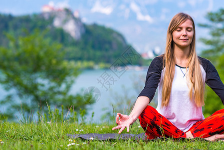 在湖边做瑜伽的女人背景图片