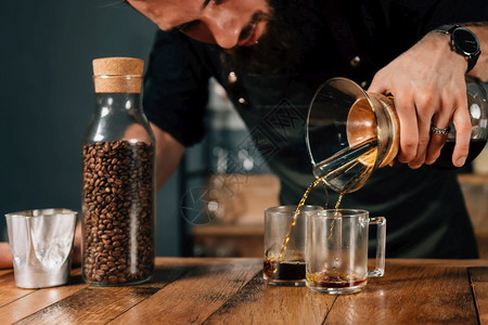 咖啡厅用两杯过滤器工具和设备在桌子上制造咖啡过滤器厅有刺青身着黑制服的纹背景图片