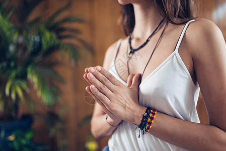 女青年站立在做瑜伽时冥想手握祈祷姿势图片
