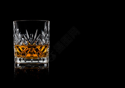 爱尔兰威士忌晶优雅玻璃杯中威士忌黑色背景反射文本空间背景