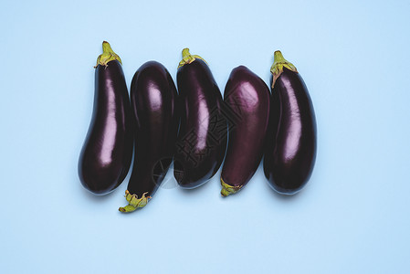 蓝桌顶端的紫色有机茄子顶端的新鲜紫色蔬菜图片