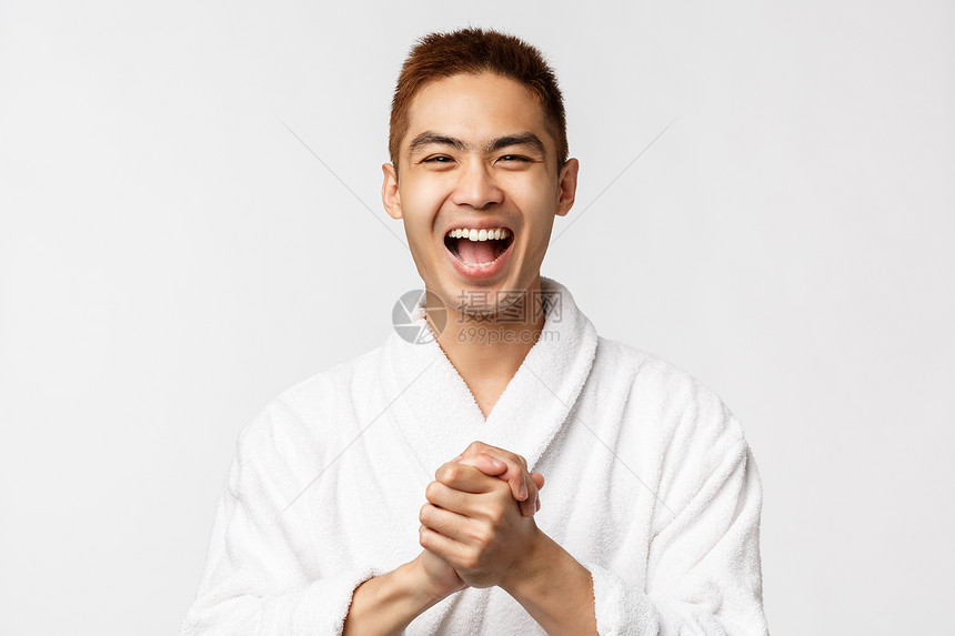 美丽spa与休闲概念美丽绝佳新闻喜悦的浴袍手拍和微笑的亚洲男子对伟大表演的欢笑掌声白背景极佳新闻喜悦的浴袍手和微笑亚洲男子白色背图片