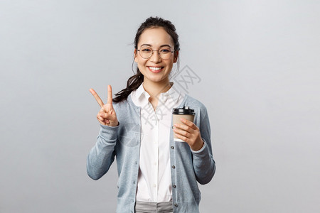 带着眼镜的女孩手拿咖啡摆着不同的姿势背景图片