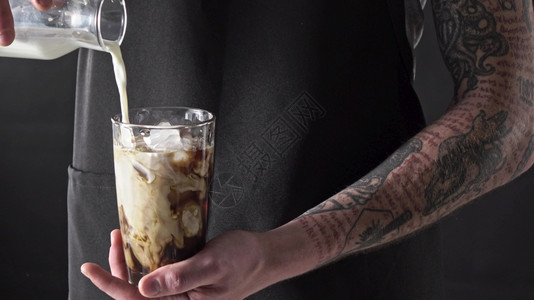冰手高清素材纹身咖啡师将新鲜牛奶倒到有冰块的玻璃上背景