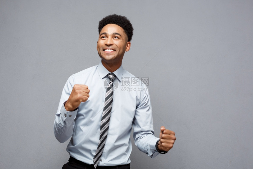 商业概念自信快乐的非洲年轻人在空中挥拳庆祝成功项目图片