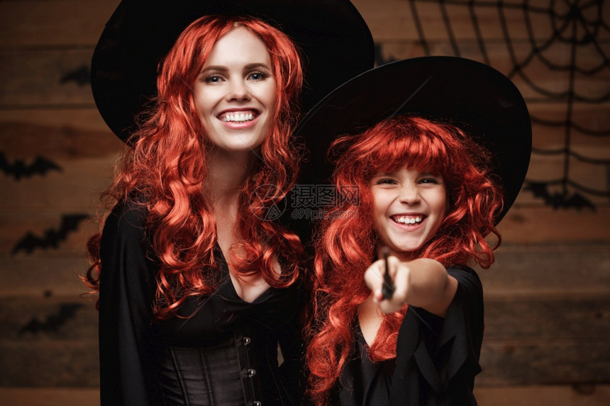 美丽的天主教母亲和女儿穿着长红头发的天主教母亲和女儿图片