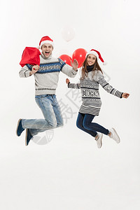 情侣拿着圣诞礼物在空中跳跃图片