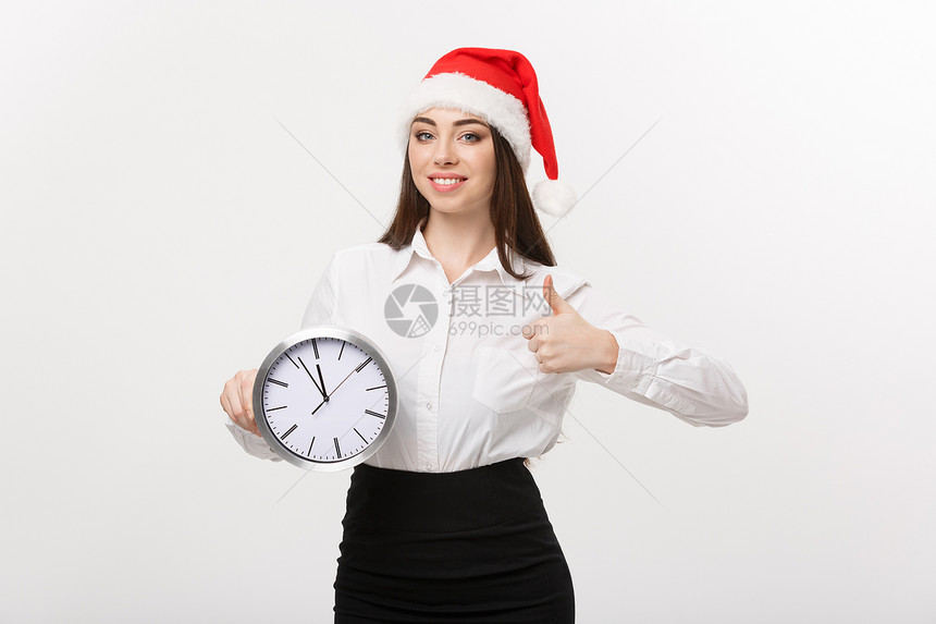 时间管理概念年轻女商人戴着圣塔帽有时钟在白色背景中脱身图片