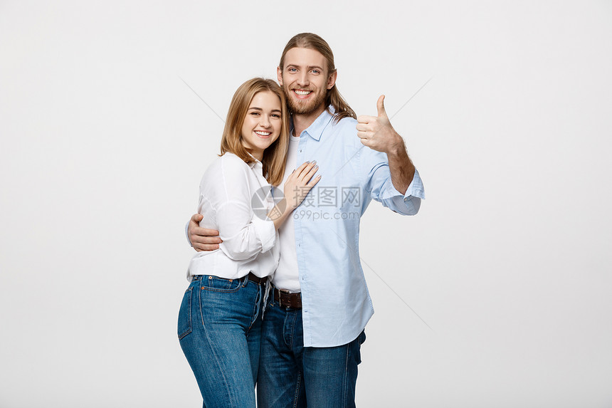 快乐的一对年轻夫妇肖像展示在白色背景上被孤立的拇指展示在白色背景上被孤立的拇指图片