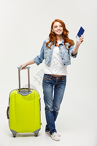 旅行和生活方式一名穿着夏季服装身护照和飞行机票的兴奋年轻高加索女肖像她当时正站在一个亮黄色背景上被孤立的手提箱上身着浅黄色背景上旅游高清图片素材