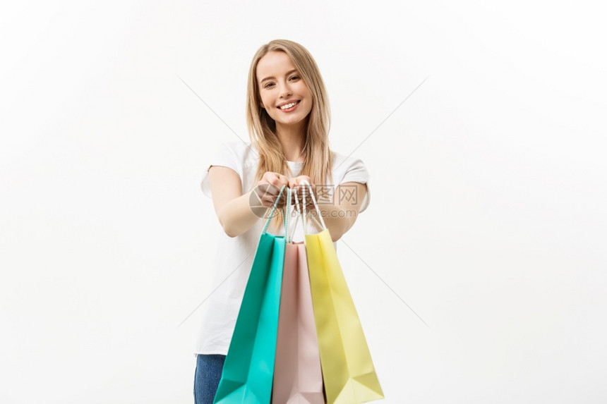 快乐的有吸引力天主教妇女提供白色背景的购物袋快乐的有吸引力天主教妇女提供白色背景的购物袋图片