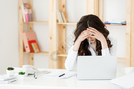 女人的头长期坐在办公室计算机桌的年轻女商人长期坐在办公室计算机桌的年轻女商人背景