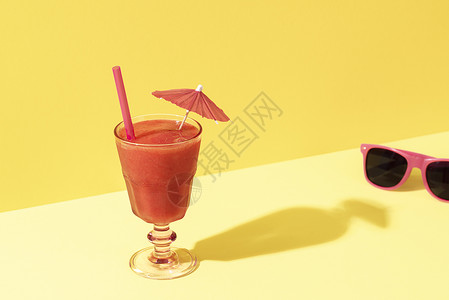 花岗岩的伞草莓冰淇淋鸡尾酒伞和太阳镜在明亮的黄色背景上夏季冷饮阳光明媚的暑假环境背景