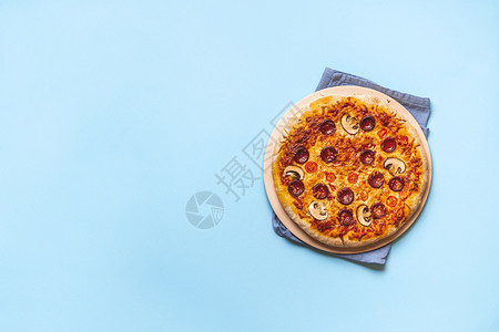 香肠比萨披萨上美味的辣椒尼披萨烤箱新鲜的披萨蓝色无缝背景平躺着准备吃披萨真正的意大利菜背景