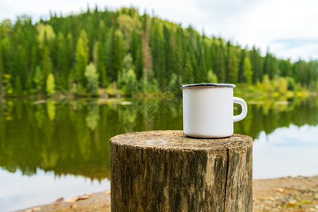 白色露营火甜咖啡杯模拟树桩和河岸风景空杯子模拟设计推广背景图片